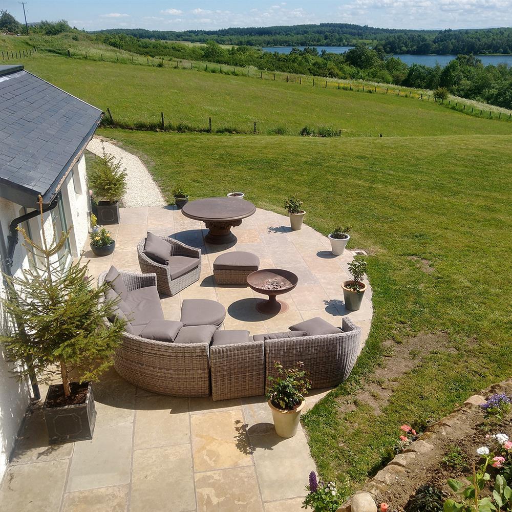 Curved natural stone patio in a large open garden